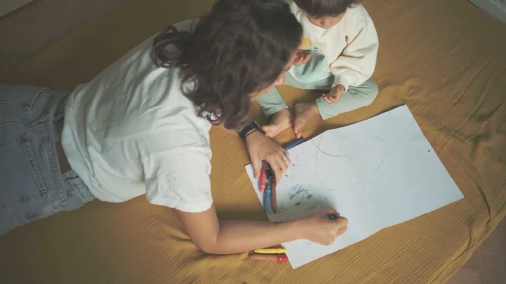 Una donna e una bambina disegnano sul tappetone